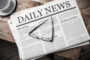 Business Newspaper on wooden desk with glasses and coffee cup, Daily Newspaper mock-up concept photo