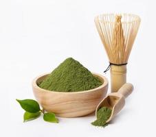 Matcha green tea powder in bowl with Organic green tea leaf and Japanese wire whisk isolated on white background, Organic product from the nature for healthy with traditional style photo