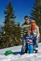 family having fun on fresh snow at winter vacation photo