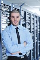 young it engineer in datacenter server room photo