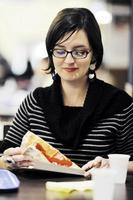 mujer come pizza en el restaurante foto