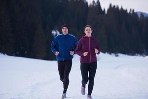 pareja trotando afuera en la nieve foto
