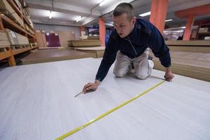 carpenter measuring wooden board photo