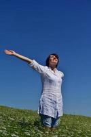 mujer joven con los brazos extendidos hacia el cielo foto
