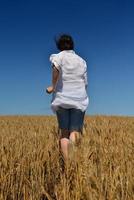 mujer joven en campo de trigo en verano foto