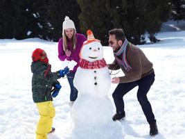 happy family making snowman photo