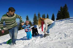 family having fun on fresh snow at winter vacation photo