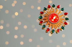 Diya lamp lit on white background with bokeh lights. Diwali festival concept. photo