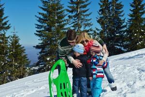 family having fun on fresh snow at winter photo