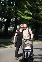 couple with baby pram in summer park photo