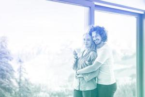 young couple enjoying morning coffee by the window photo