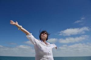 happy young woman with spreading arms to sky photo