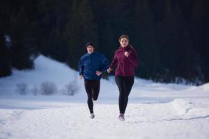 pareja trotando afuera en la nieve foto