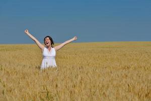 young woman in wheat field at summer photo