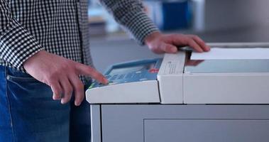 Male Assistant Using Copy Machine in modern office photo