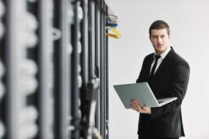 businessman with laptop in network server room photo