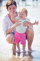 mamá y bebé en la playa se divierten foto