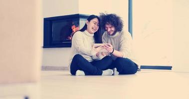 Young Couple using digital tablet on the floor photo