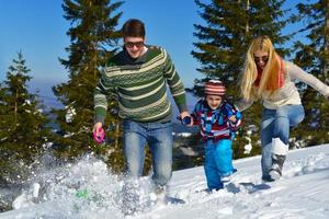 family having fun on fresh snow at winter photo