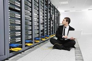 businessman with laptop in network server room photo