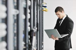 businessman with laptop in network server room photo