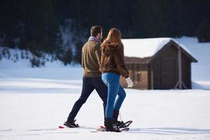 pareja divirtiéndose y caminando con raquetas de nieve foto