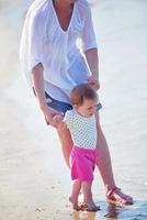 mamá y bebé en la playa se divierten foto