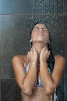 sexy young woman enjoing bath under water shower photo