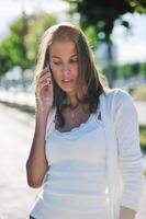 young woman talk by cellphone on street photo