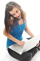 una joven trabaja en una laptop aislada en blanco foto