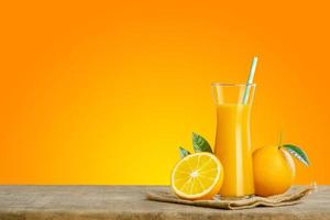Glass of fresh orange juice on wooden table, Fresh fruits Orange juice in glass with group on orange color  background with copy Space for your text. photo