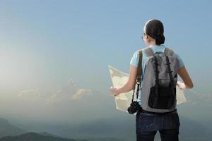 Travelling tourist with her backpack on the top of iceberg mountain in the nature and look searching direction on location map, Adventure and travel in the mountains region concept photo