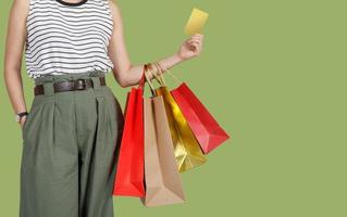 mujer de compras con bolsas de compras y tarjeta de crédito en fondo verde, espacio de copia para su texto, concepto de estilo de vida de marketing digital de comercio electrónico foto