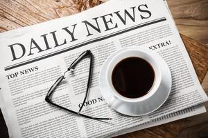 Business Newspaper on wooden desk with glasses and coffee cup, Daily Newspaper mock-up concept photo