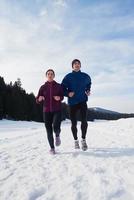 pareja trotando afuera en la nieve foto