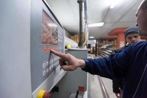 carpintero calculando y programando una máquina de trabajo de madera cnc foto