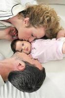 indoor portrait with happy young family and  cute little babby photo