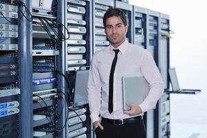 businessman with laptop in network server room photo