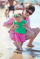 mamá y bebé en la playa se divierten foto