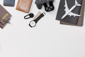 Top view mockup of Traveler's accessories with passport, books of travel plan, wallet, camera, hat and airplane toy isolated white background with empty space,Tropical travel concept photo