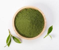 polvo de té verde matcha en un tazón con hoja de té verde orgánico aislado sobre fondo blanco, producto orgánico de la naturaleza para la salud con estilo tradicional foto