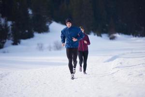 pareja trotando afuera en la nieve foto