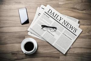 Newspaper with the headline News and glasses and coffee cup on wooden table, Daily Newspaper mock-up concept photo
