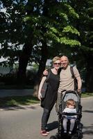 pareja con cochecito de bebé en el parque de verano foto