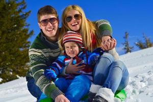 family having fun on fresh snow at winter vacation photo