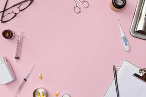 Creative flatlay of doctor medical equipment pink table with stethoscope, medical documents, thermometer, syringe and pills, Health care concept, Top view with copy space, Isolated on pink photo