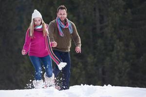 pareja divirtiéndose y caminando con raquetas de nieve foto