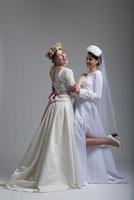 Portrait of two beautiful young bride in wedding dresses photo