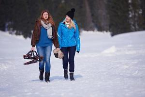 pareja divirtiéndose y caminando con raquetas de nieve foto