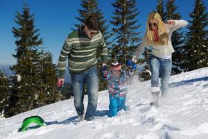 family having fun on fresh snow at winter photo